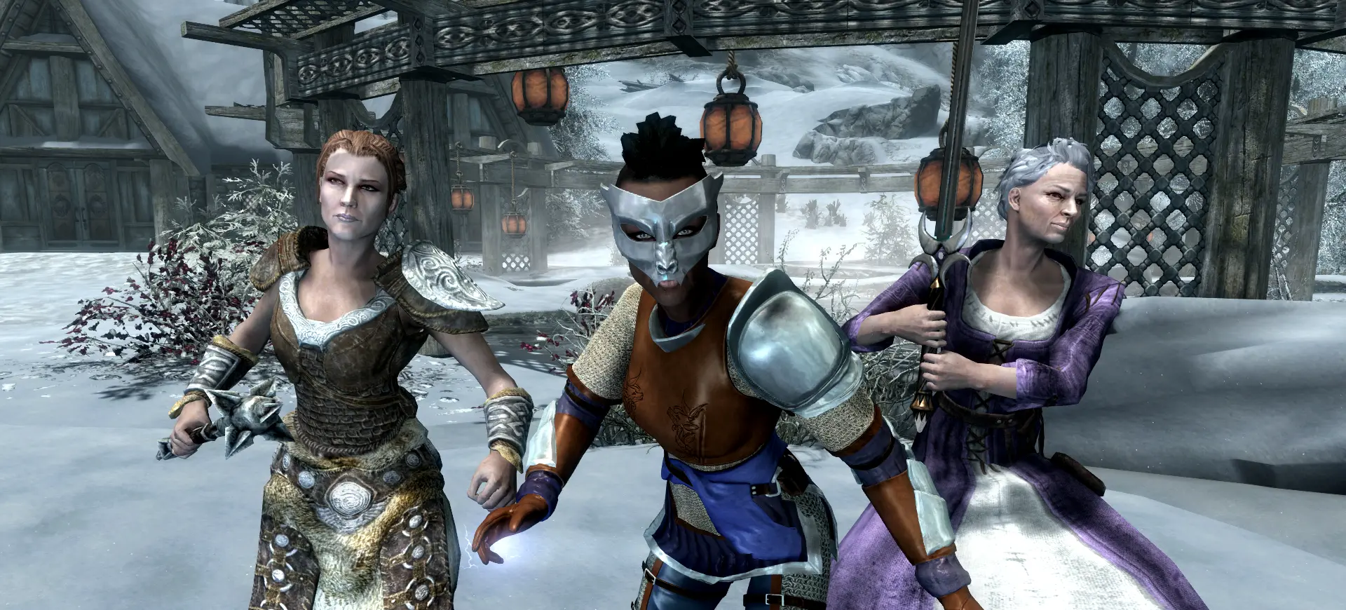 Three armoured and robed Skyrim characters posing in a snowy village, showing community made mods